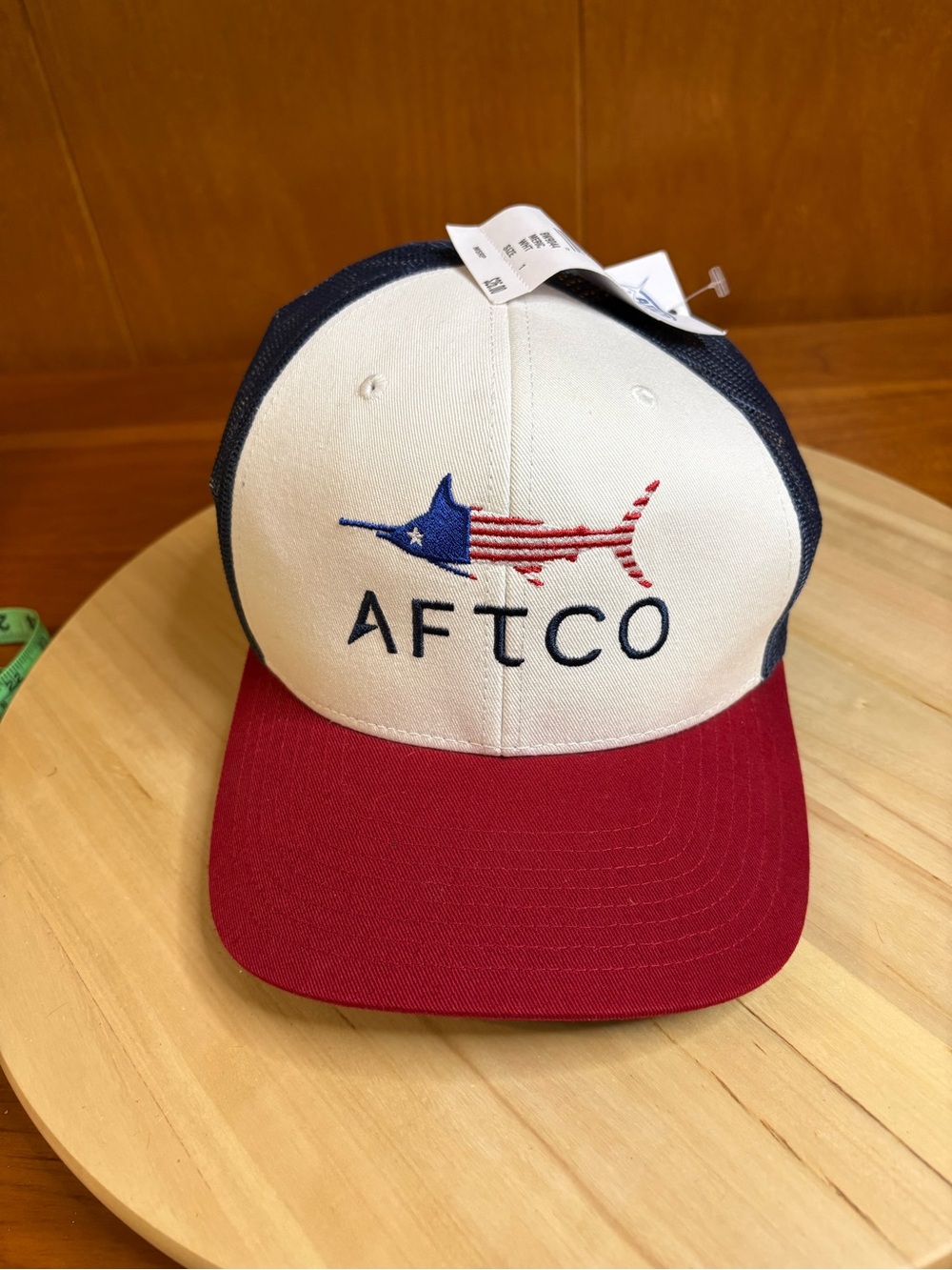AFTCO Meric trucker hat with an embroidered American flag billfish graphic. NWT